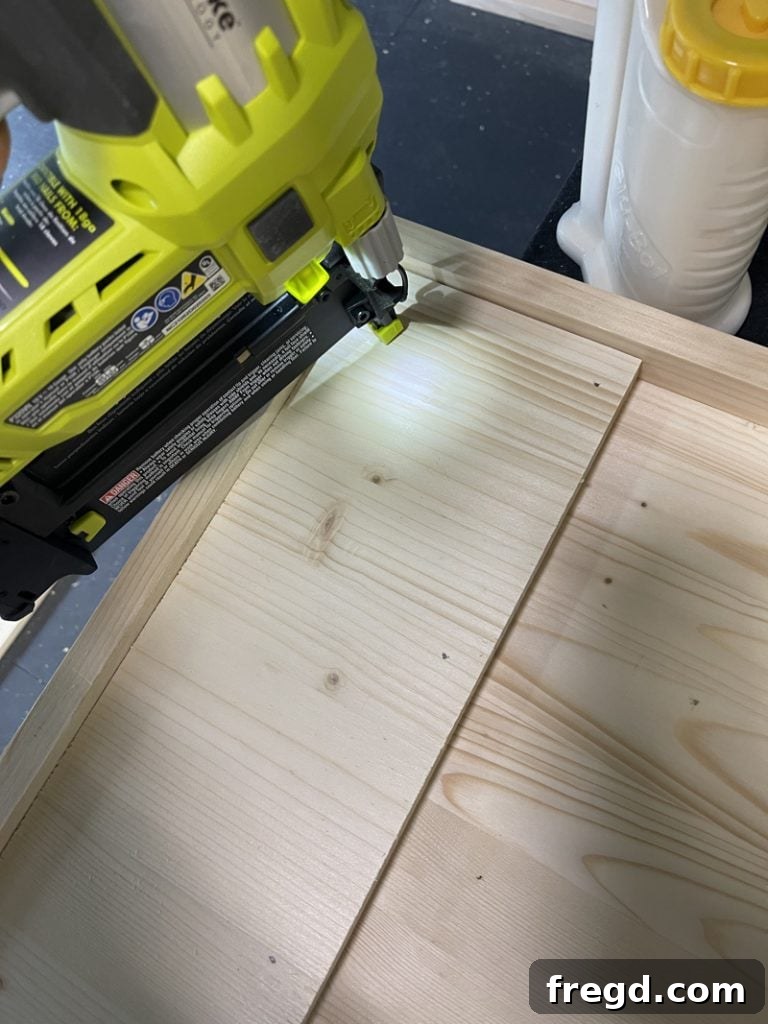 Applying wood glue to the underside of the tabletop where a leg support board will be placed.