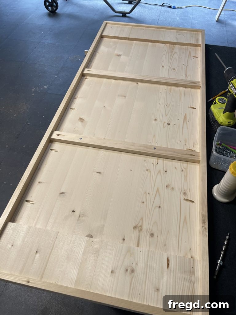 Close-up of a completed leg support board attached to the underside of the tabletop with brad nails.