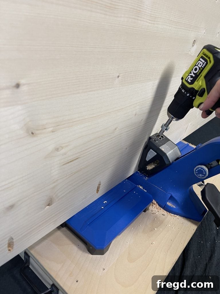 Close-up shot of a Kreg pocket hole jig in action, drilling precise holes into a wood board.