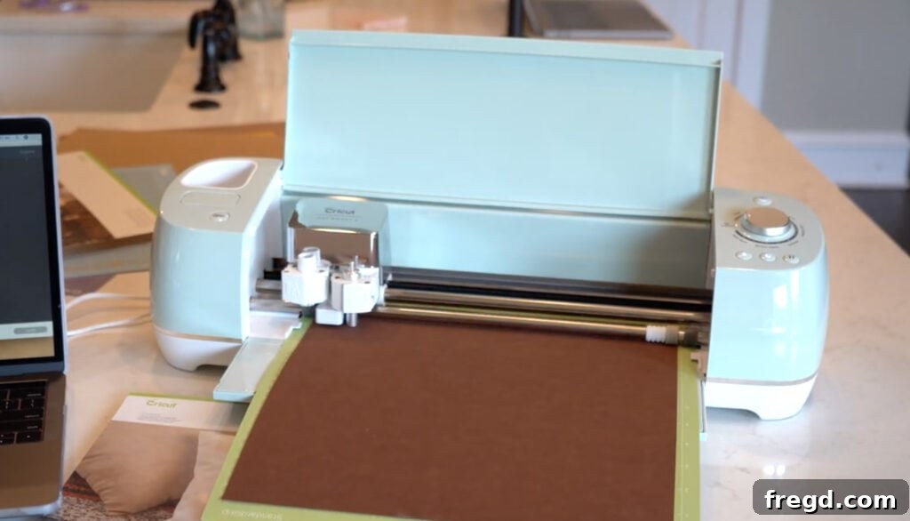 Effortless Farmhouse Wood Sign Decor 3 Cricut machine and various crafting materials used for DIY projects.