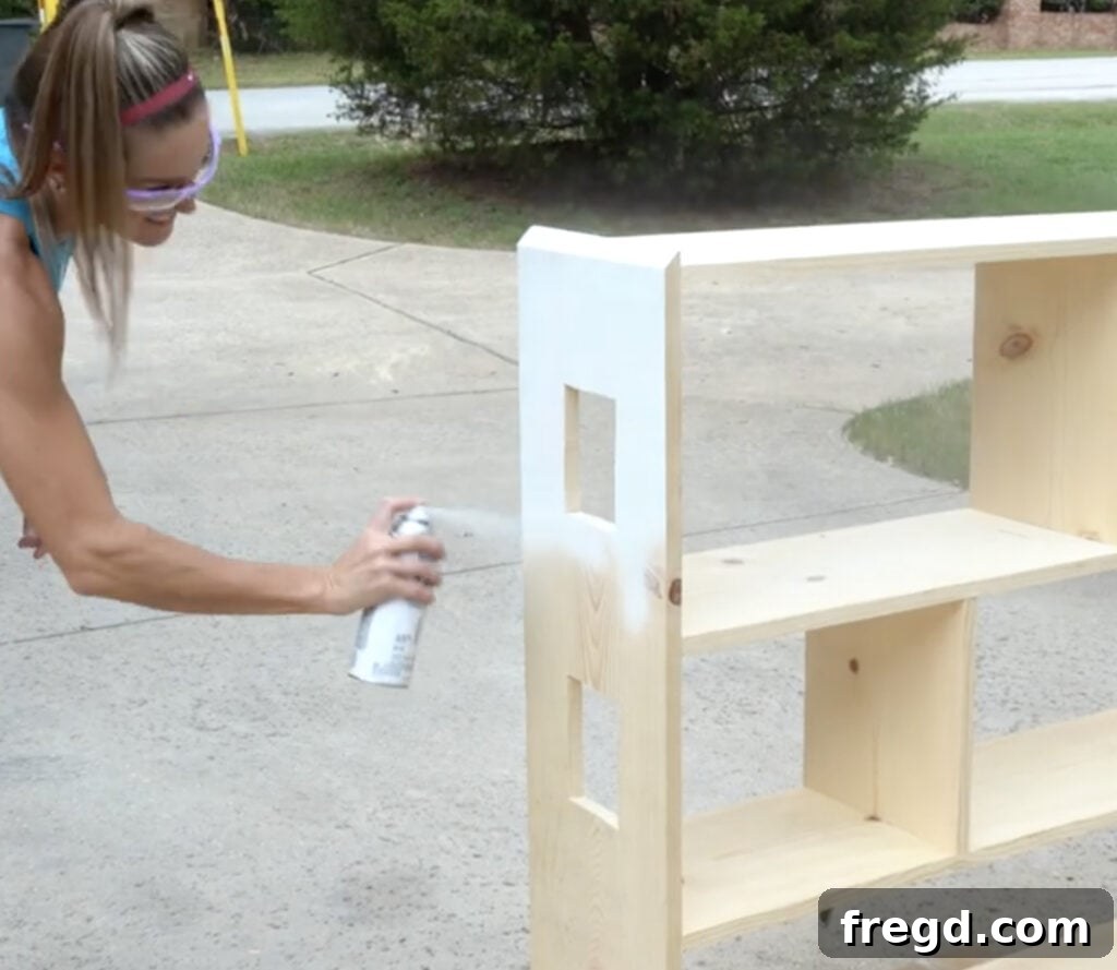 Craft a Charming Dollhouse Book Nook 17 Spray painting the main body of the dollhouse bookcase white