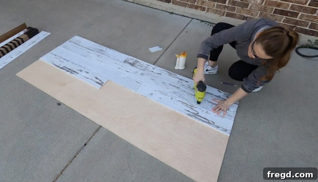 Craft Your Own Canopy Bed 23 Attaching barn wood planks to plywood for headboard