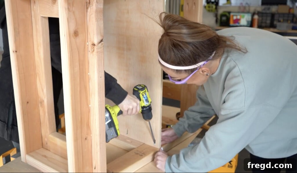 Modern DIY Nightstand with Hidden Storage Drawer 13 Securing the plywood shelf into the nightstand frame with pocket hole screws and wood glue