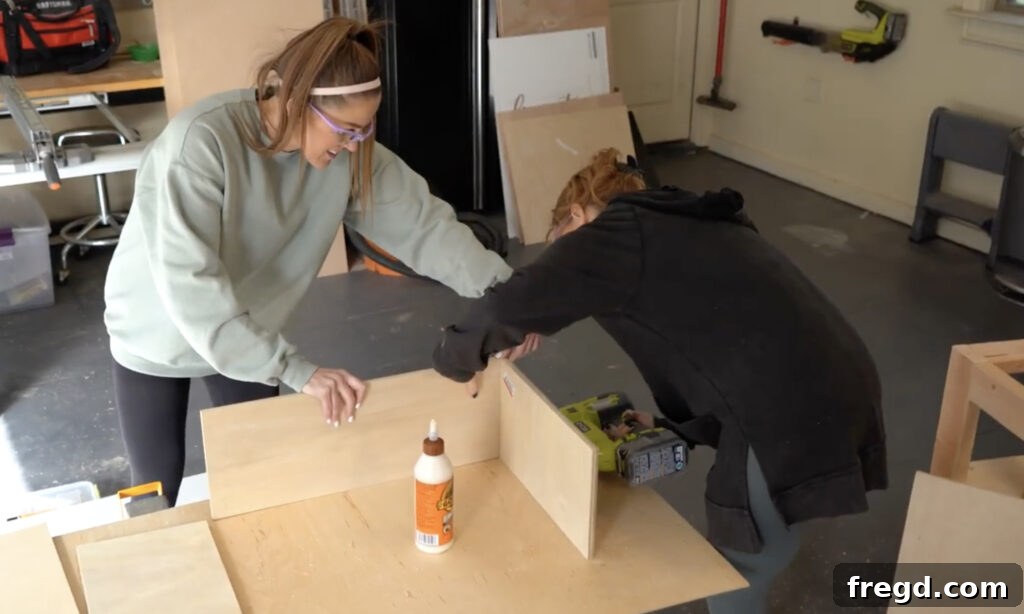 Modern DIY Nightstand with Hidden Storage Drawer 14 Assembling the drawer box by attaching plywood sides, front, and back with glue and staples/nails