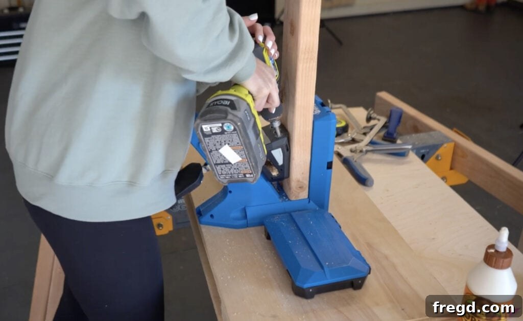 Modern DIY Nightstand with Hidden Storage Drawer 3 Drilling pocket holes with a Kreg Jig on a wood piece for nightstand frame
