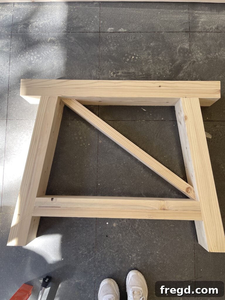 Fitting an X-bracing piece into the leg assembly.