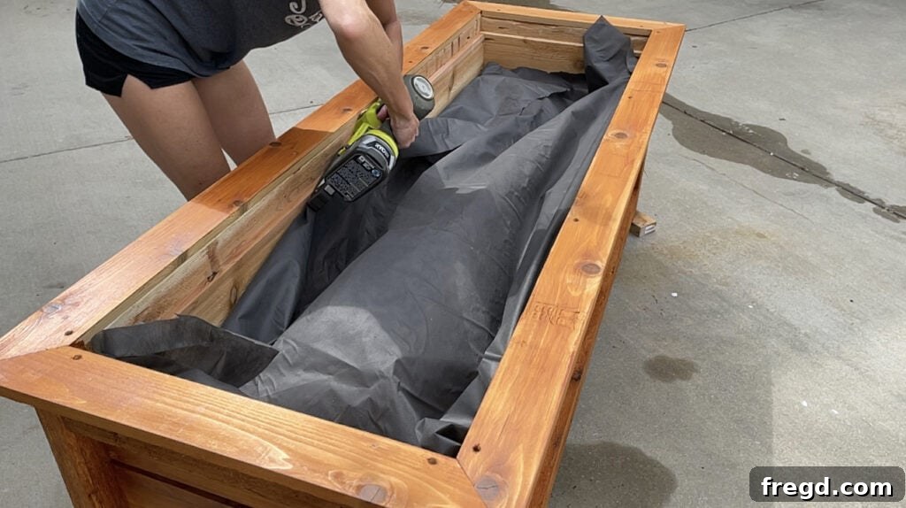 Lining the inside of the raised planter box with landscape fabric