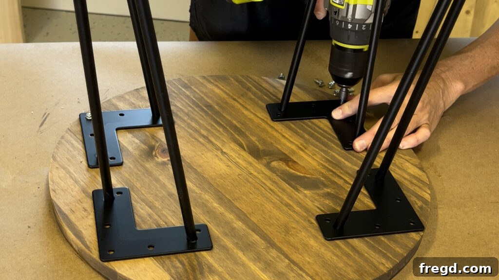 Attaching hairpin legs to the finished wood circle to create a side table.