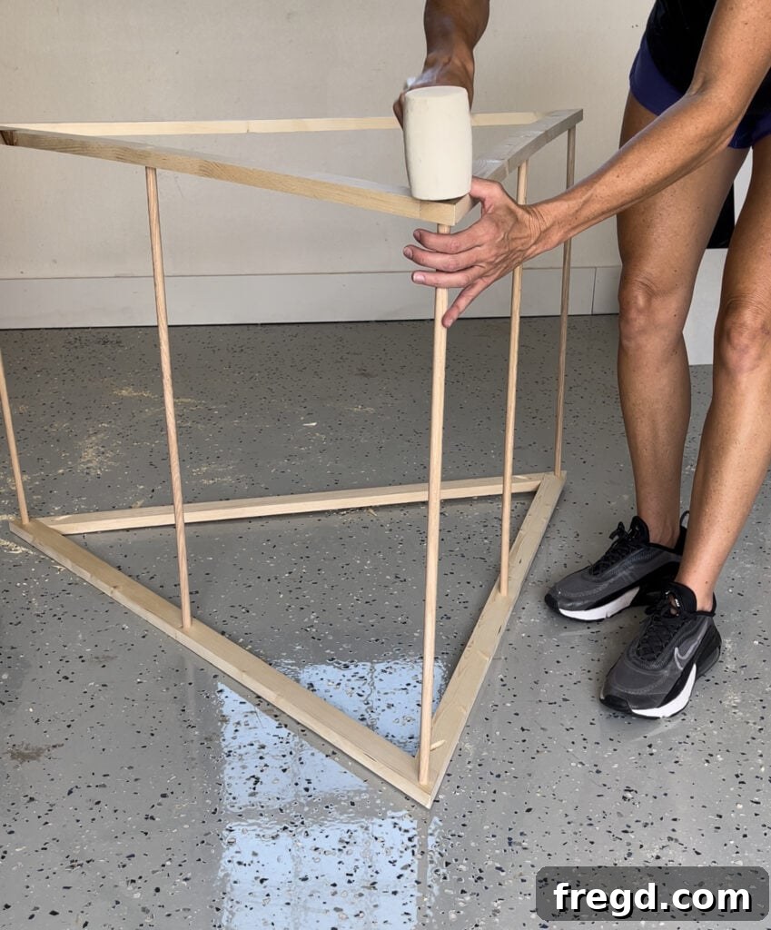 Assembling the second frame over the dowels to complete the doghouse tent
