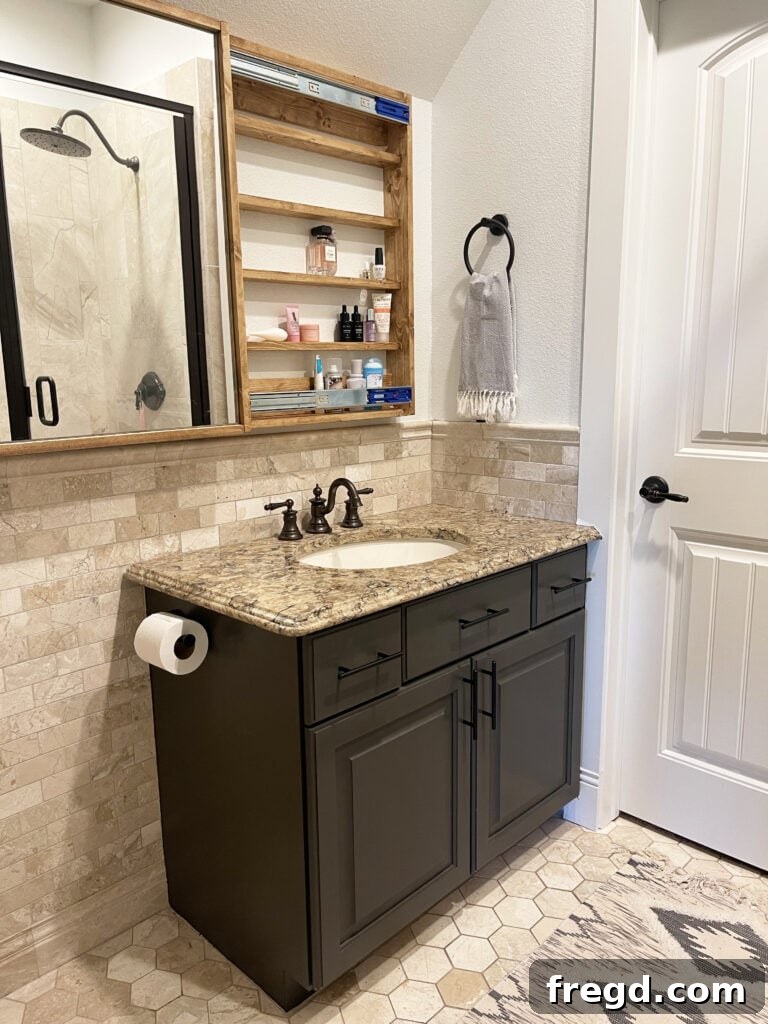 Elevate Your Bathroom with DIY Mirrored Storage 21 The bathroom mirror with hidden storage revealed, showcasing neatly organized beauty products and toiletries.