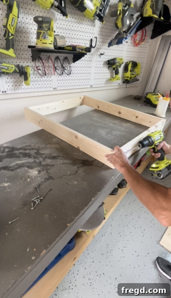 Elevate Your Bathroom with DIY Mirrored Storage 4 Demonstrates the assembly of the main cabinet frame using pocket hole screws and wood glue for strong joints.