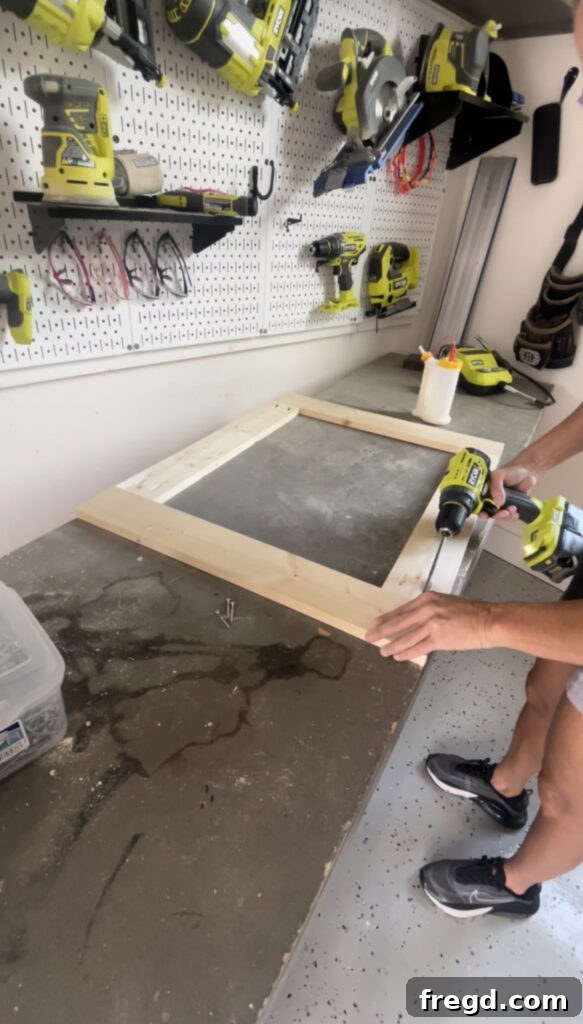 Elevate Your Bathroom with DIY Mirrored Storage 8 Depicts the assembly of the mirror frame using pocket hole screws and wood glue.