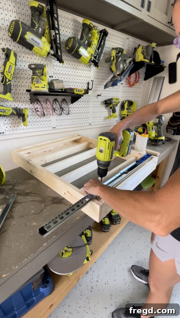 Elevate Your Bathroom with DIY Mirrored Storage 10 Depicts the attachment of the main, wider drawer slide pieces to the cabinet's front cleats.