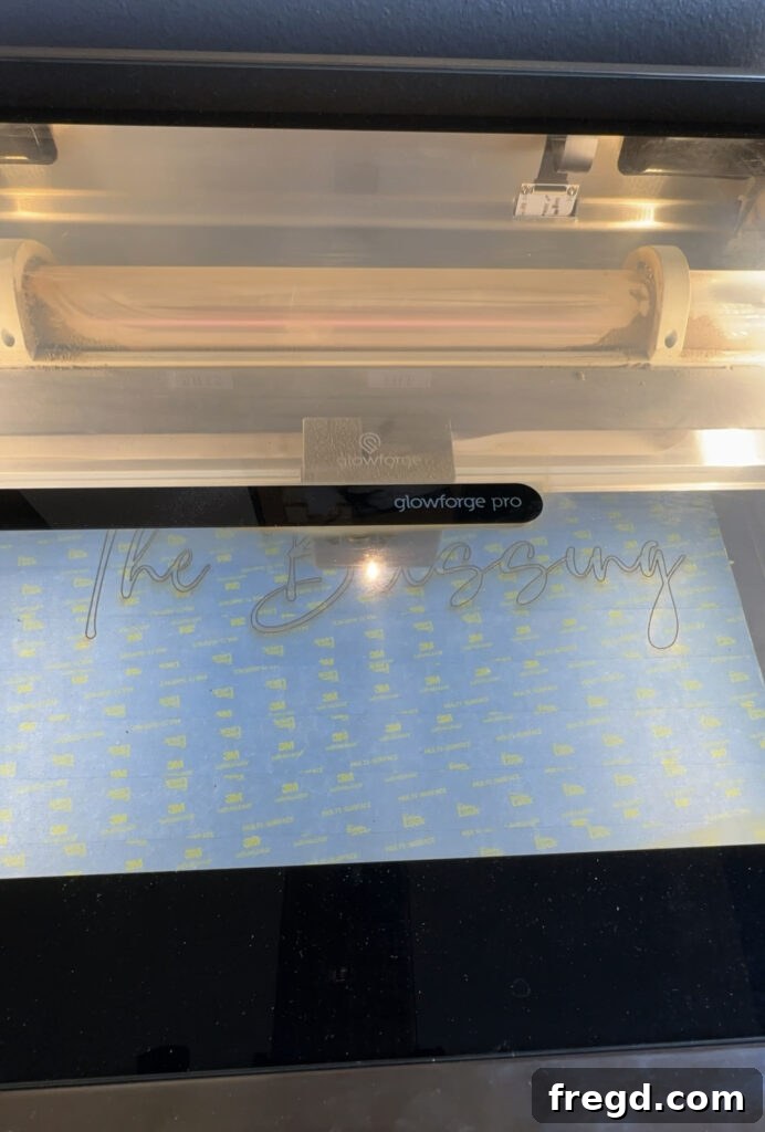 Glowforge laser cutter in action, cutting words from medium draft board.