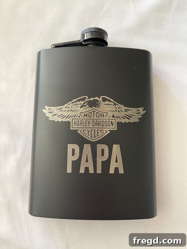 Stainless steel flask with a custom laser-engraved logo or text.