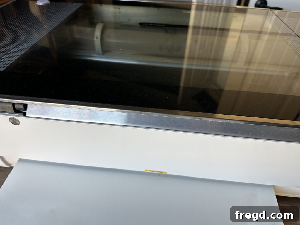 Eucalyptus board being fed through the open passthrough slot of a Glowforge Pro.
