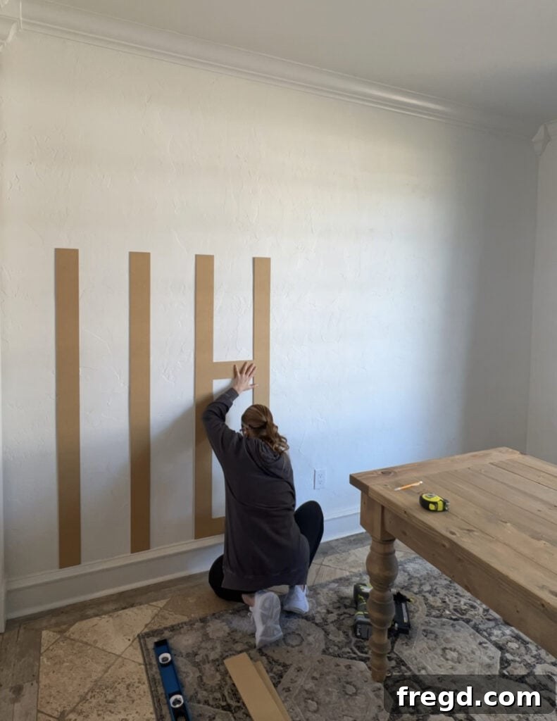 Transform Your Home with DIY Board and Batten Paneling 5 Attaching subsequent vertical battens using a custom-made scrap wood spacer to maintain consistent 9.25-inch gaps.