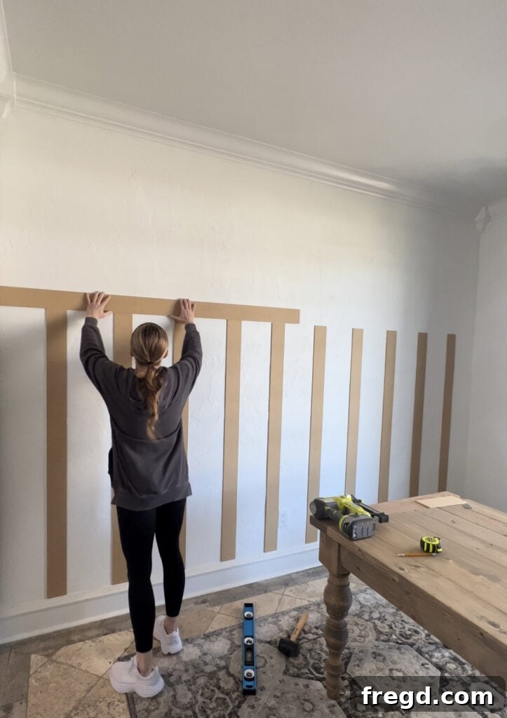 Transform Your Home with DIY Board and Batten Paneling 7 The first horizontal bender board being installed, ensured to be level and firmly secured.