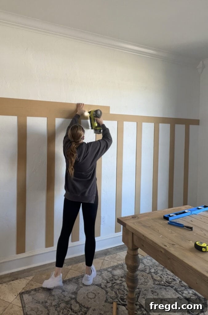 Transform Your Home with DIY Board and Batten Paneling 8 The second horizontal bender board being stacked precisely on top of the first, creating a double-layered effect.