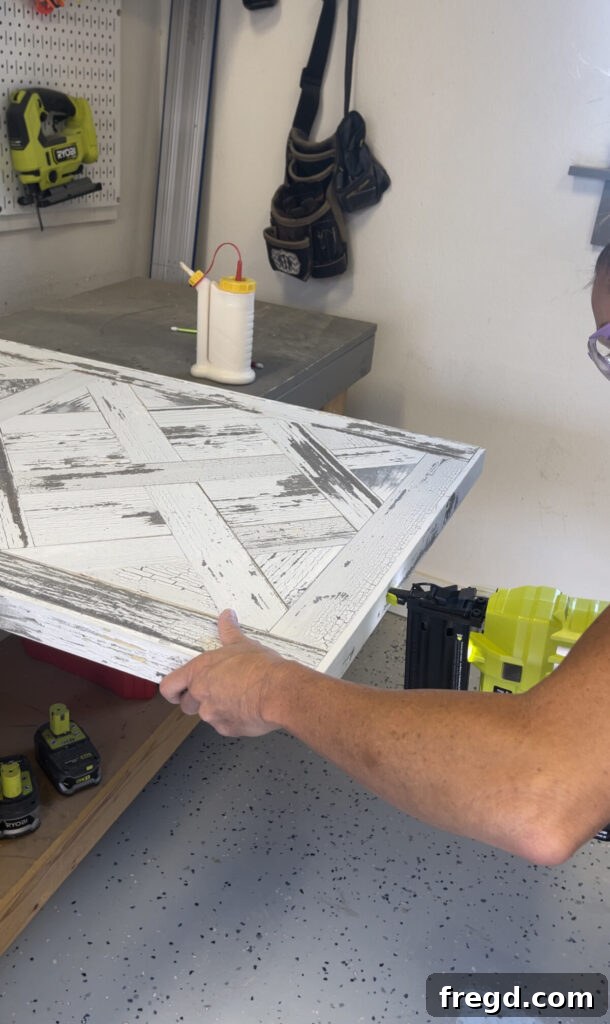 Short trim pieces being measured and attached to the ends of the coffee table top, completing the frame.