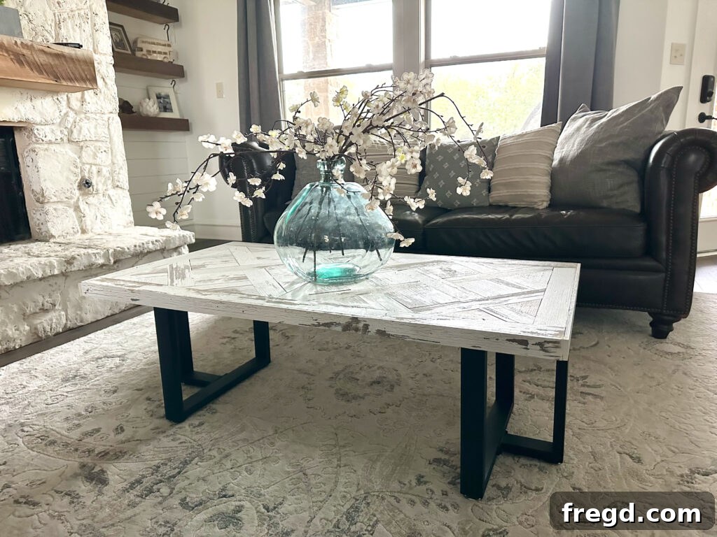 The finished DIY coffee table proudly displayed in a modern farmhouse living room, showcasing the parquet top and metal legs.