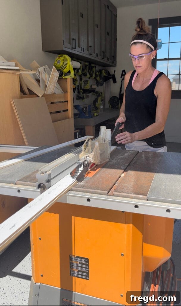 A long barn wood plank being ripped on a table saw to create frame pieces for the coffee table.