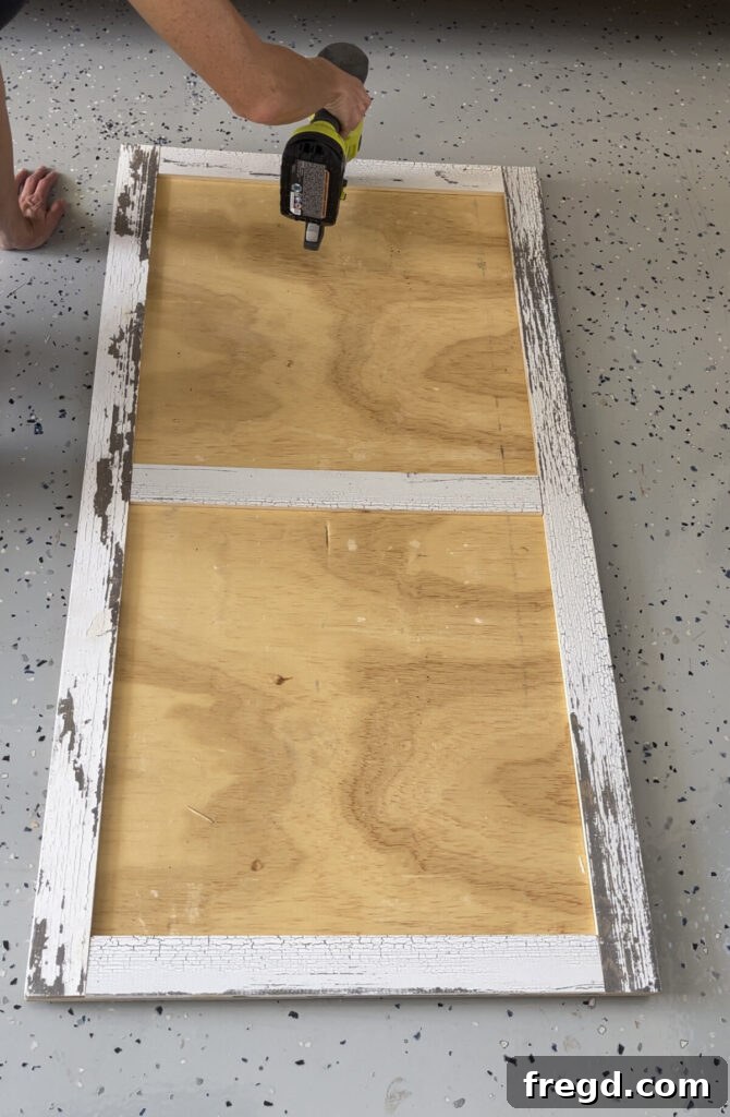 Short frame boards being measured, cut, and attached to complete the rectangular perimeter of the coffee table top frame.