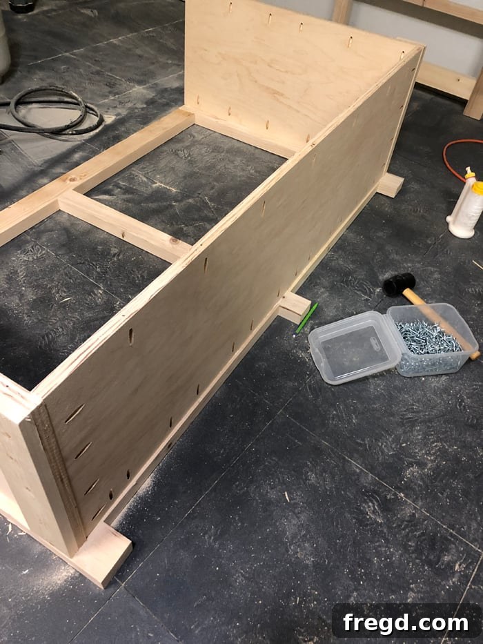 Build Your Own Elegant Buffet Table 12 An interior view of the cabinet's base, with the bottom plywood panel fully installed and securely fastened, demonstrating a solid foundation.
