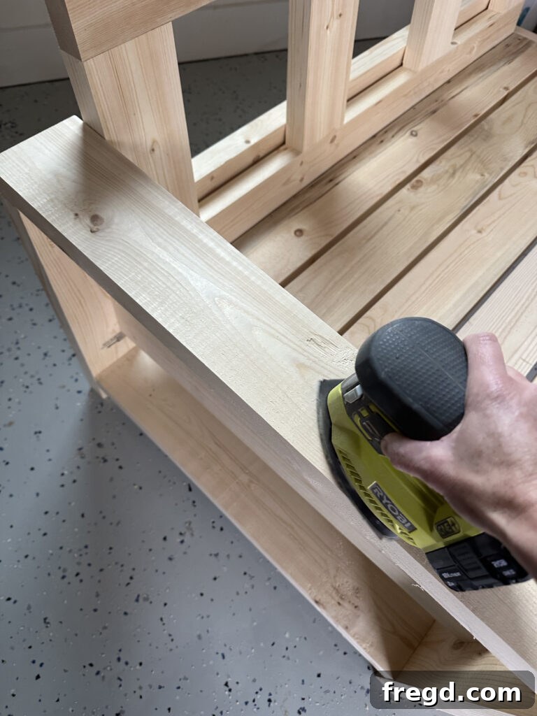 Sanding the DIY outdoor couch with a power sander
