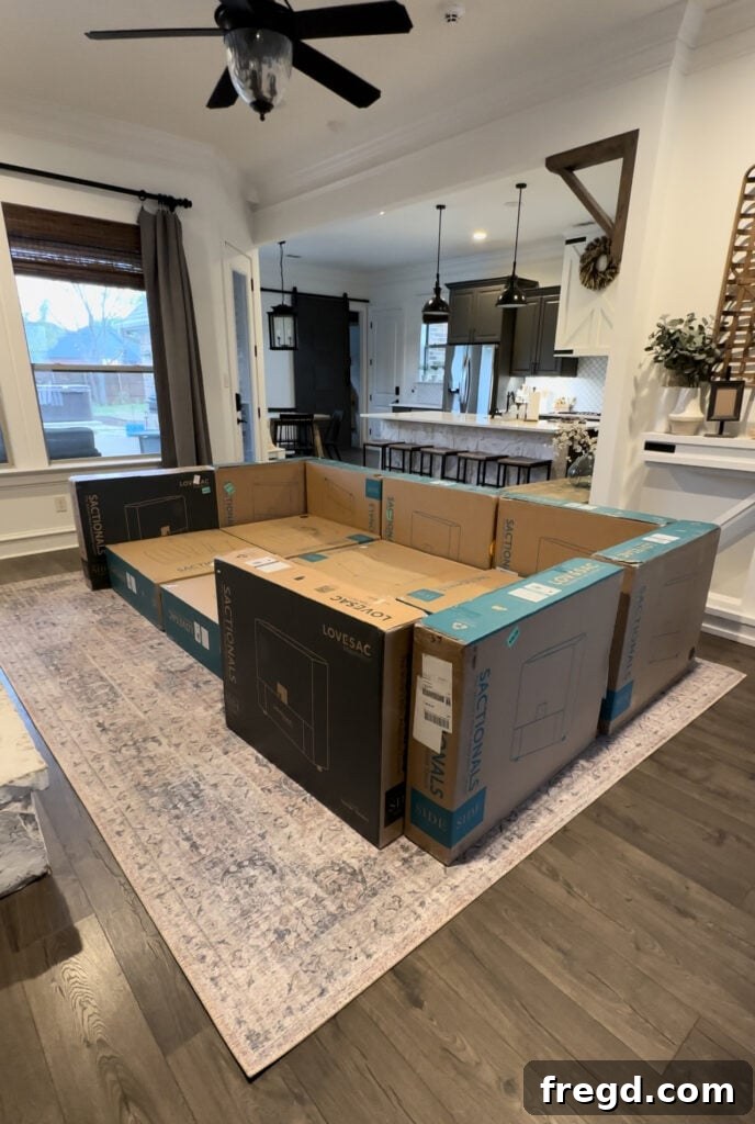 A stack of Lovesac boxes in a living room, arranged to preview the planned sectional layout, ready for unboxing.