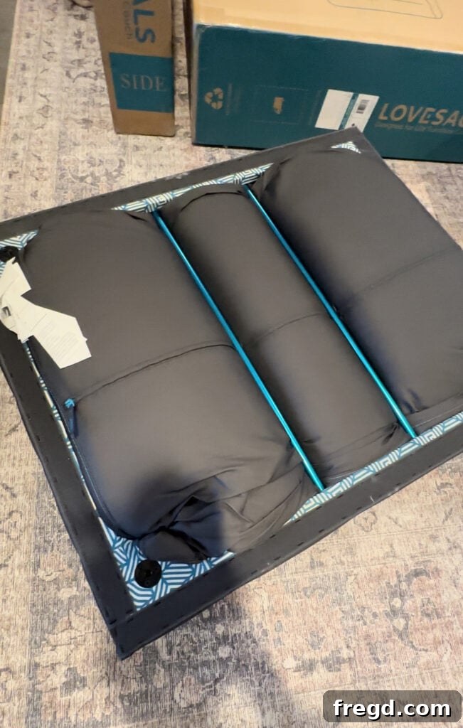 Several Lovesac boxes are open, revealing neatly packed sectional components and cushions, indicating the start of assembly.