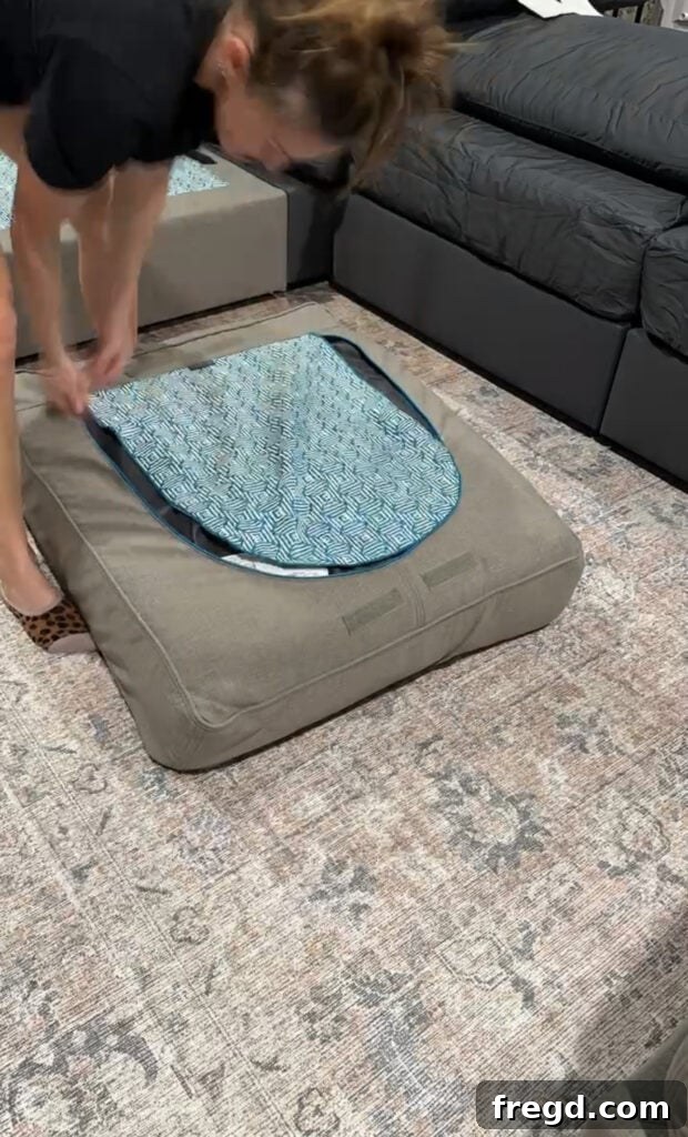 Another view of a Lovesac Sactional piece being covered, highlighting the detailed construction and fabric texture.