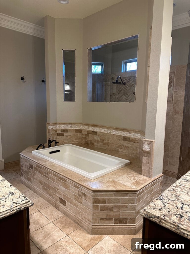 Master Bath Oasis Reimagined 2 Before master bathroom remodel showing beige travertine and tight shower entry.