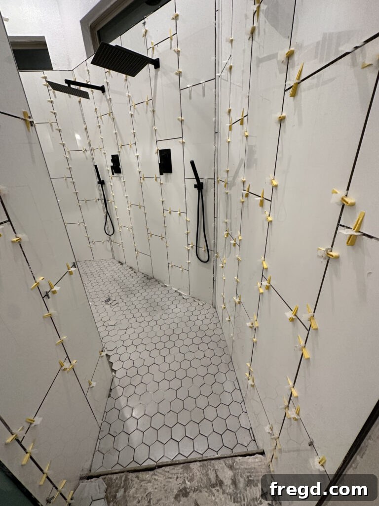 Master Bath Oasis Reimagined 17 Shower interior with small gray hex tile and rain shower heads.