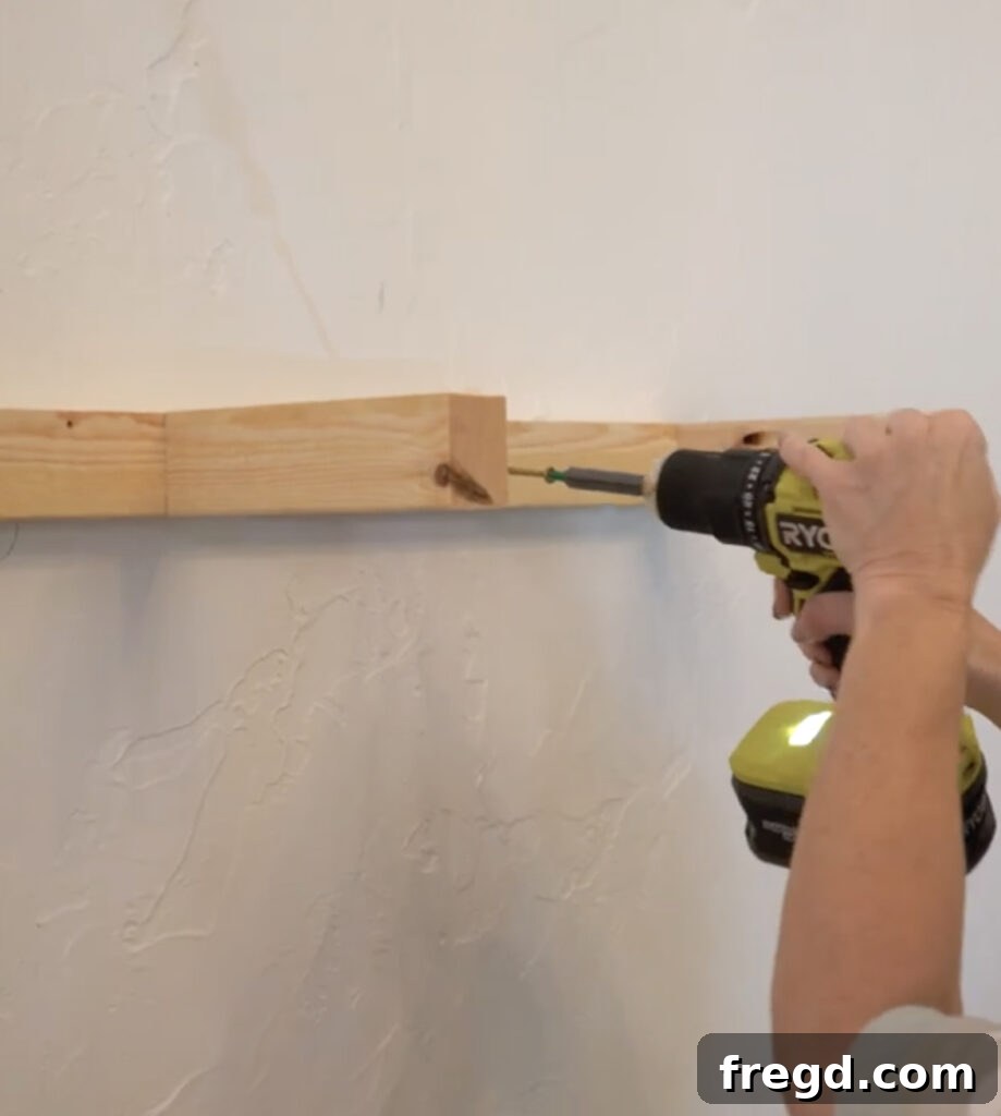 Modern Dining Room Makeover DIY Floating Shelves 8 Attaching the floating shelf cleat to wall studs with long wood screws
