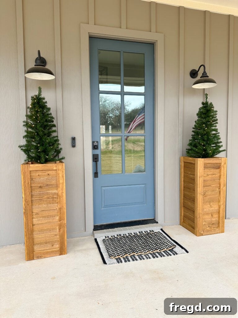 Close-up of a DIY cedar planter box filled with lush Christmas greens and pinecones, showcasing its golden oak stain.