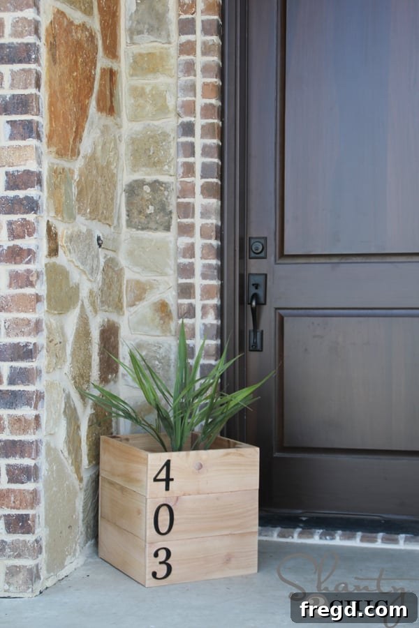 A stylish cedar planter box with an attached address plaque, perfect for enhancing curb appeal.