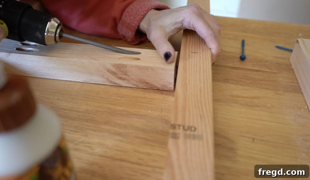 Woodworker attaching short rung pieces to long legs of a planter box frame using pocket hole screws and wood glue.