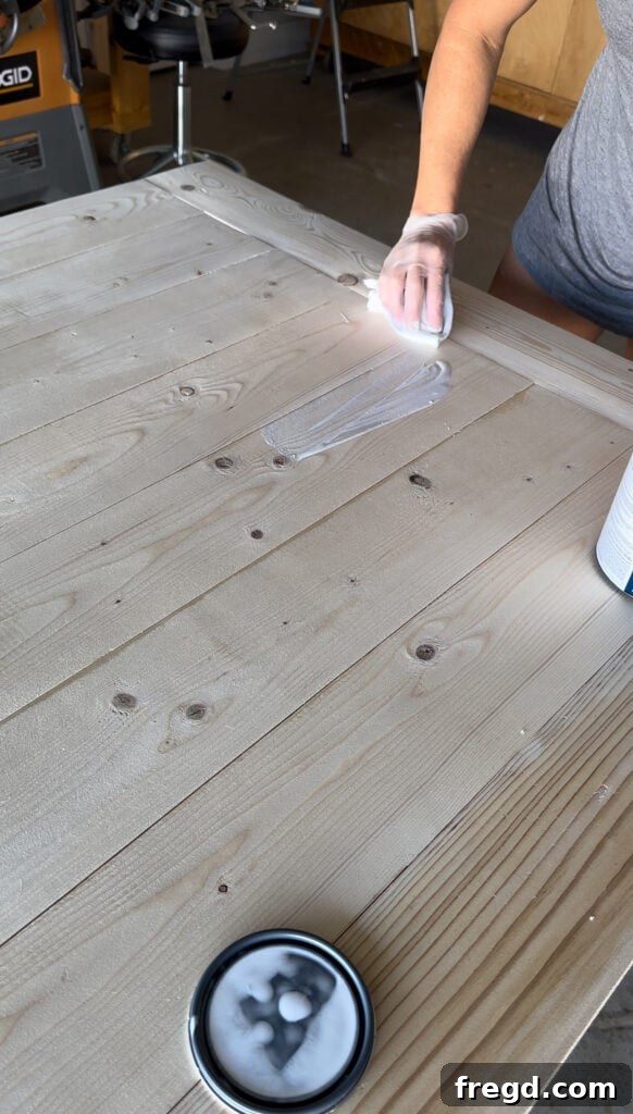 Build Your Own Dining Table with Free DIY Plans 21 Wiping excess white wash pickling stain from the table