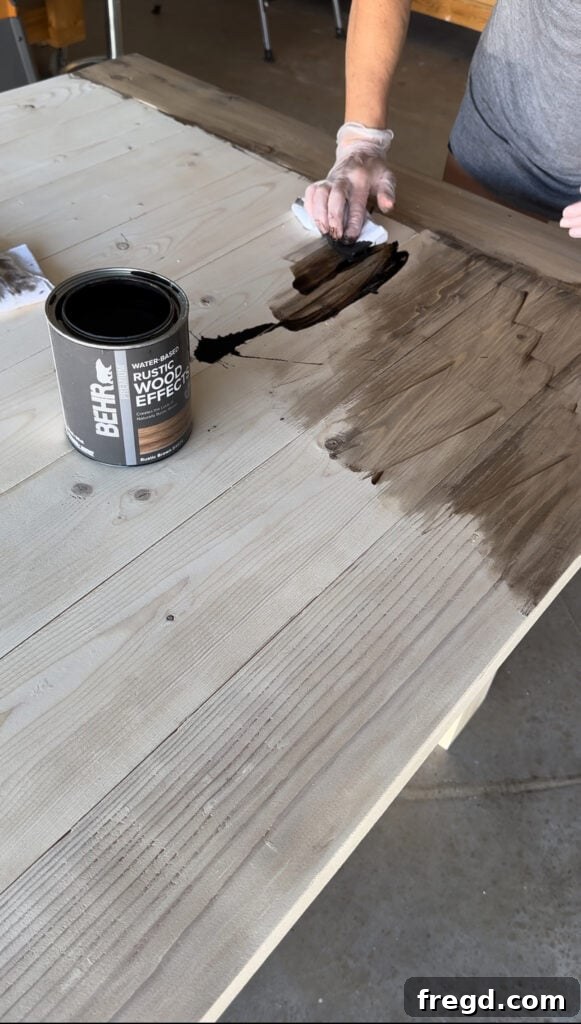 Build Your Own Dining Table with Free DIY Plans 23 Wiping off excess Rustic Brown stain from the dining table