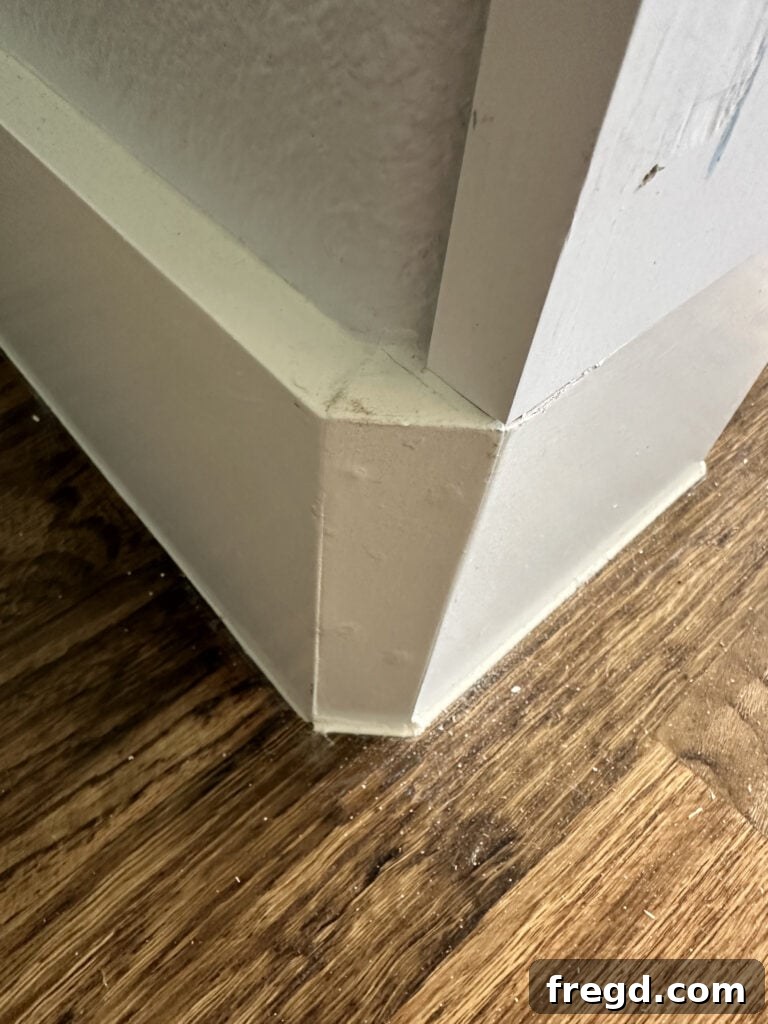 Existing base molding installed around a rounded corner opening, showing the challenge.