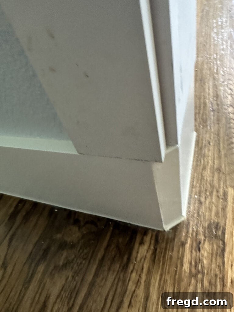 Vertical side trim piece placed against the rounded corner to assess overhang and solution.