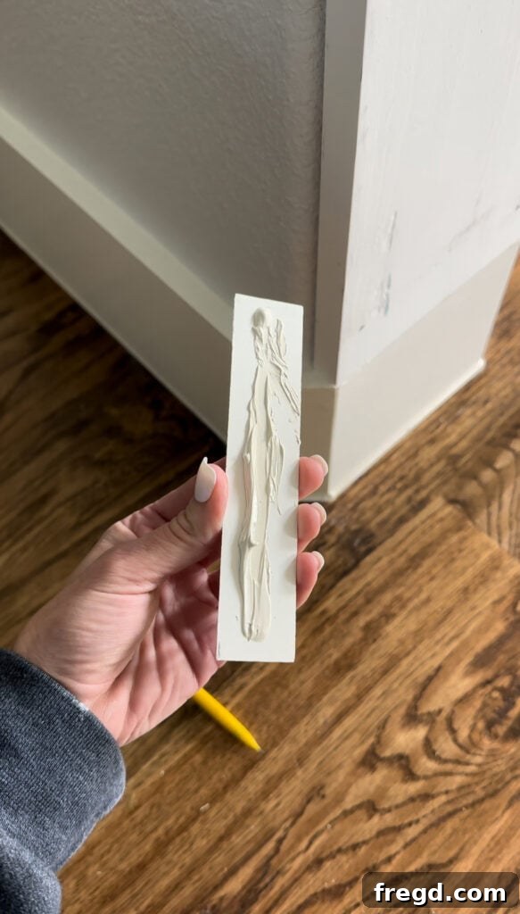 Small corner molding piece being cut to square off the rounded base.