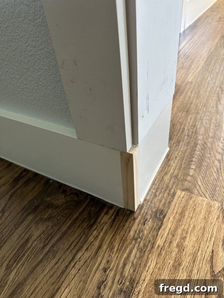 Attaching the vertical trim board, aligning with the reveal marks.
