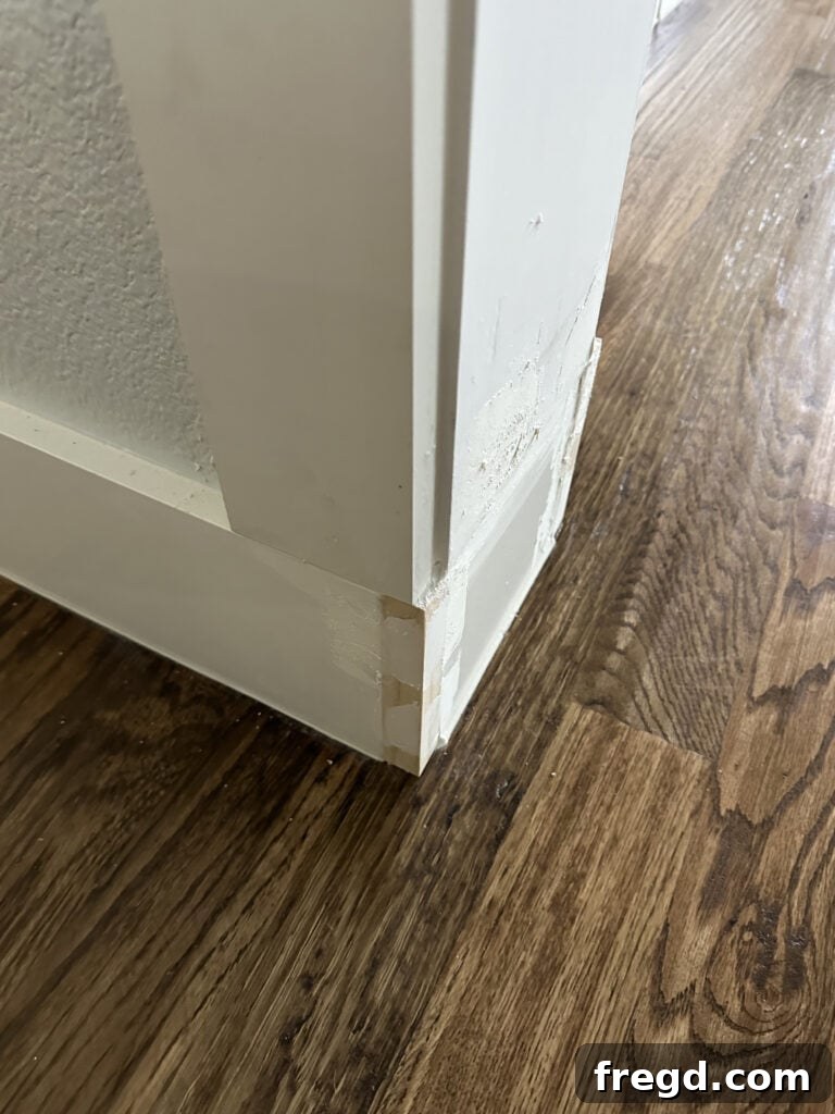 Filling nail holes and imperfections with wood filler before adding the bottom trim blocks.