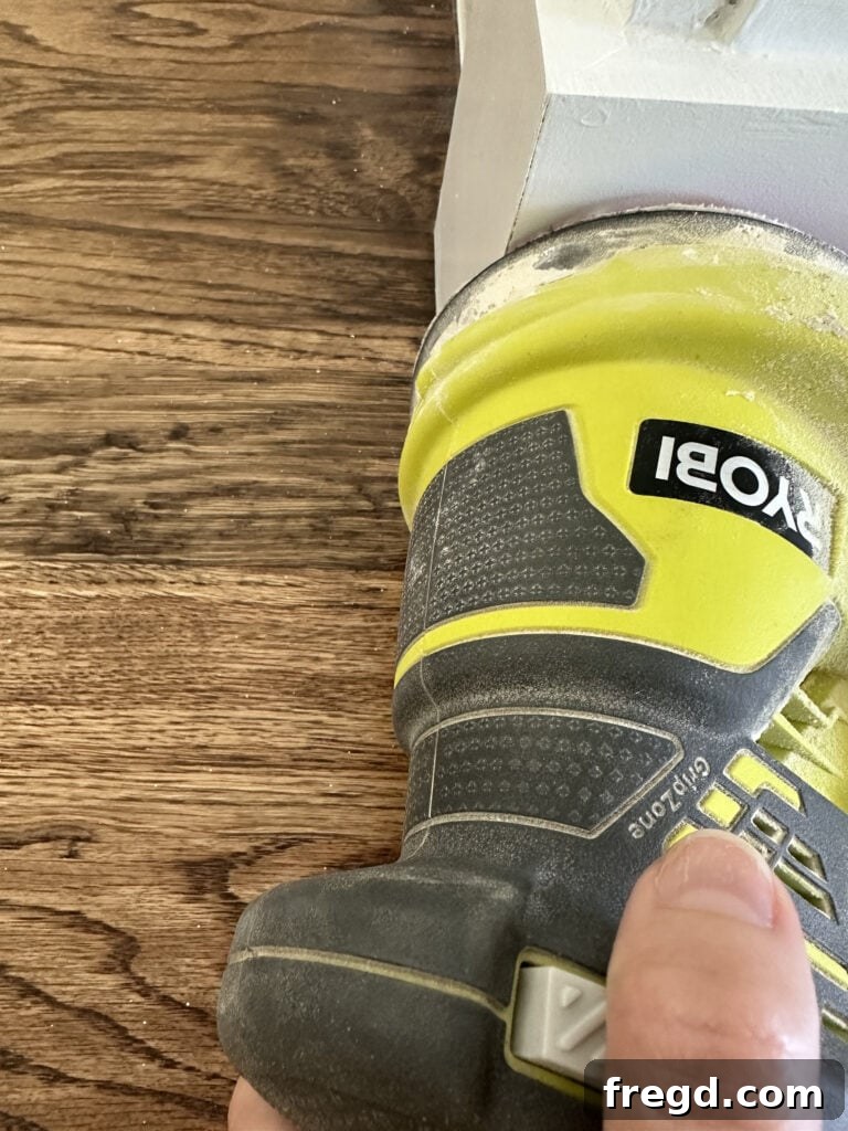 Sanding all wood filler and trim surfaces for a smooth, paint-ready finish.