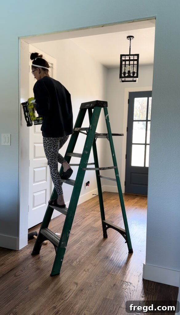 Applying liquid nails to the vertical frame board before installation.