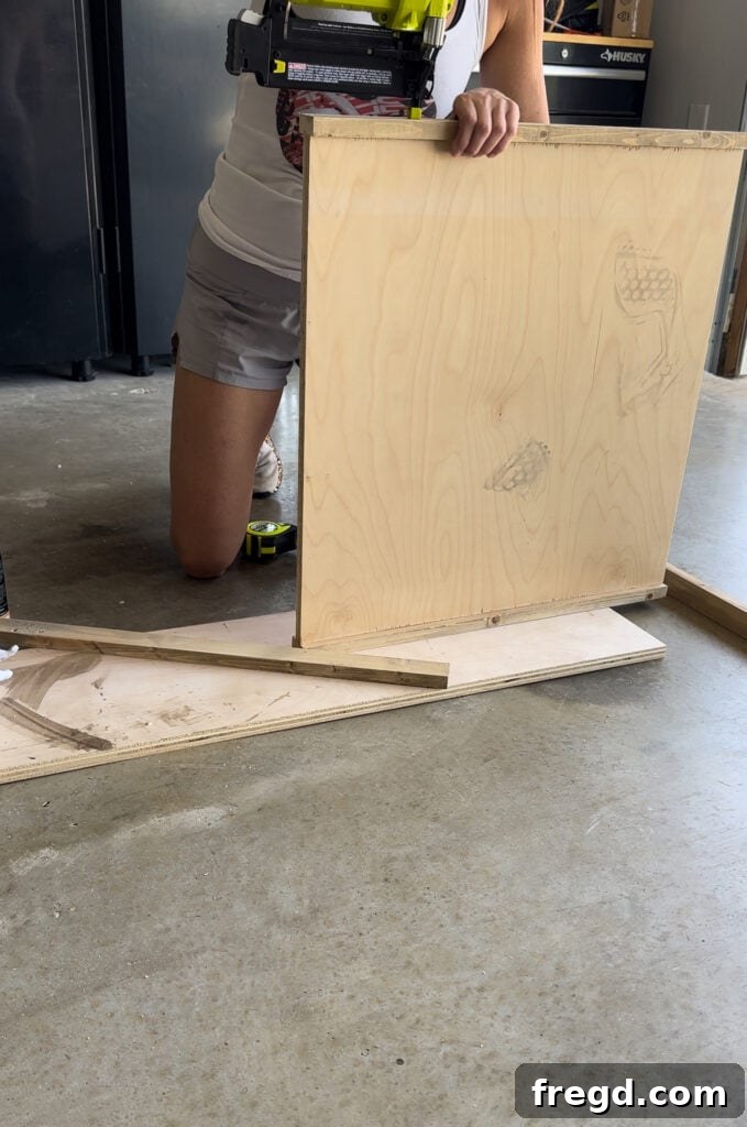 Nature's Eternal Canvas 11 Attaching the side trim pieces to the plywood frame with a brad nailer
