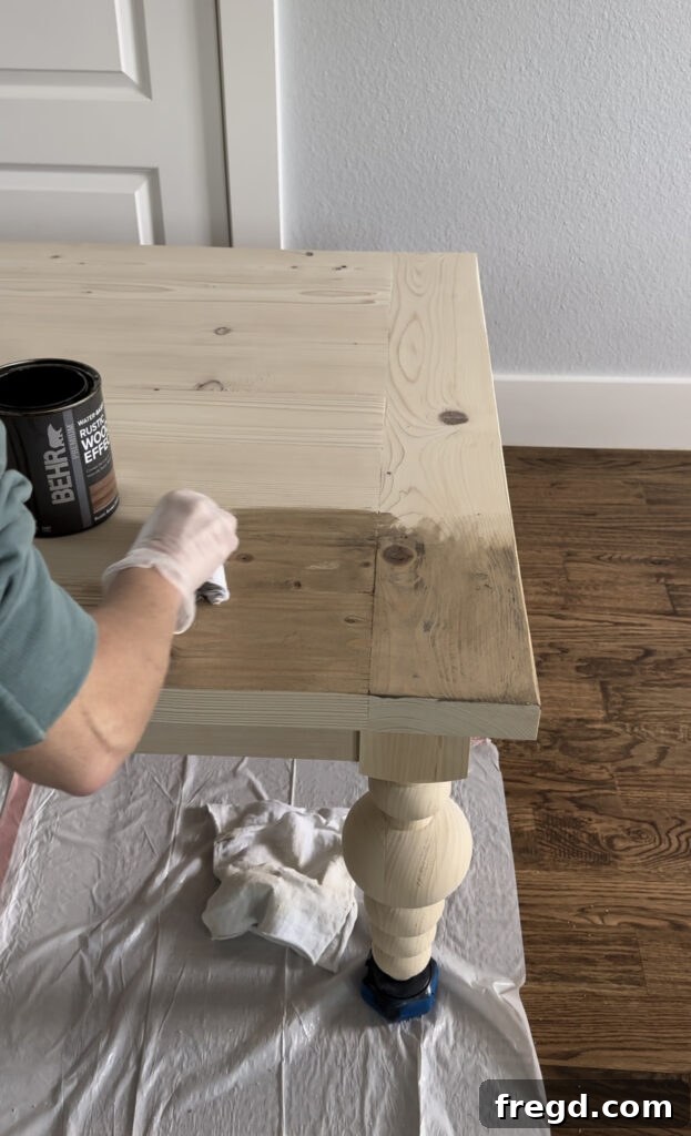 Applying the first coat of white wash pickling stain to the coffee table