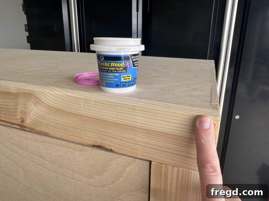 Craft Your Own Custom Dresser 28 Applying wood filler to nail holes on the dresser